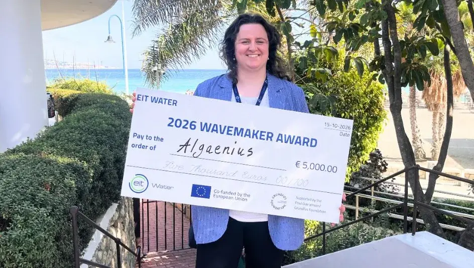 Founder Meinke van Oenen holding the 2026 EIT Wavemaker Award cheque made out to Algaenius, on the seafront in Málaga